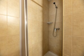 A shower area with beige tiles, a showerhead, and a handheld shower attachment. - Apartment 'Apartamento Bilo 303' with Lake View, Wi-Fi and Air Conditioning (Es Pujols)