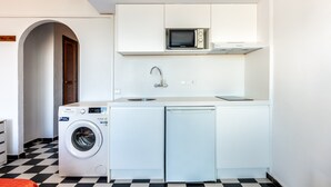 Cocina compacta con lavadora, microondas y lavavajillas.