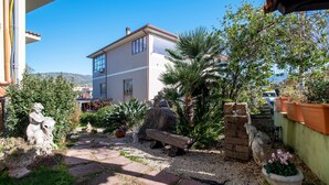 Une cour avec un bâtiment, des statues en pierre et des plantes en pot.