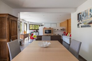 A modern dining area with a wooden table, chairs, and a decorative bowl centerpiece.