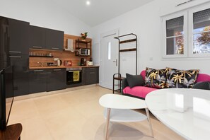 A modern kitchen with black cabinets, a wooden countertop, and a white dining table.