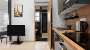 A modern kitchen with a wooden countertop, a coffee maker, and a black marble backsplash.