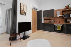 A modern kitchen with a flat-screen TV, a microwave, and a coffee maker.
