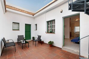 Una habitación con cama, silla, mesa y ventana.