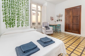 Une pièce comprenant un lit, un bureau, une chaise, une fenêtre et une porte.