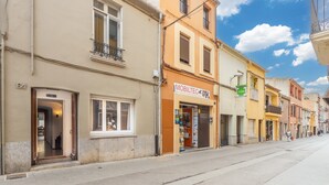 Eine Straße mit Gebäuden, eines davon mit einem Schild für 'MOBILTEC'.