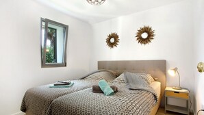 Une chambre à coucher comprenant un lit, une table de chevet, une lampe et deux éléments de décoration murale.