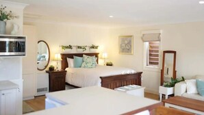 A bedroom with a bed, bedside tables, a dresser, a mirror, and a window with blinds. - Fair Linden's Morrow (Bowral)