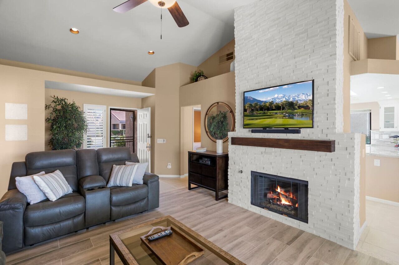 Una sala de estar moderna con chimenea, un televisor de pantalla plana grande y un sofá de cuero.