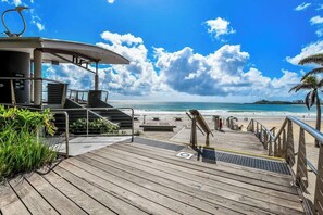 A wooden deck leading to a beach with a clear sky. - Lamer 5 Beachfront Apt Mooloolaba (Maroochydore)