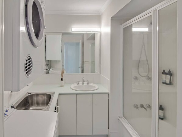 Ein modernes Badezimmer mit Waschbecken, Spiegel und Dusche.
