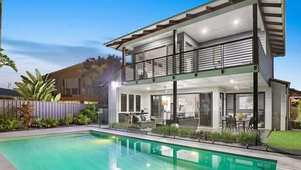 A modern two-story house with a balcony, a swimming pool, and a well-maintained garden. - Adelong Waterfront Home Mooloolaba (Buddina)