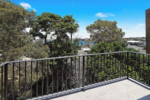 A balcony with a metal railing overlooking a parking area and trees. - Illawong 9 Beachfront Mooloolaba Apt (Mooloolaba)