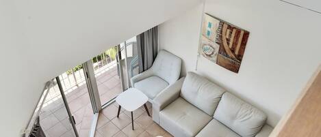 A modern interior with a sofa, a small table, and a wall with a decorative piece.