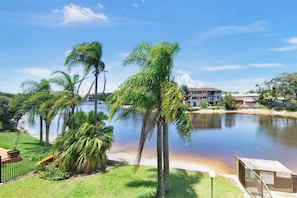 A resort with palm trees, a body of water, and a building in the background. - Hacienda 3 Canal View Comfort Apt (Mooloolaba)