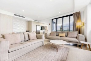 A modern living room with two sofas, a coffee table, and a large window with a view.