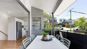A modern kitchen with a built-in oven and a dining area with a white table and chairs.