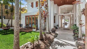A modern house with a patio, outdoor seating, and tropical plants. - Luxury Tropical Haven Mooloolaba (Mooloolaba)