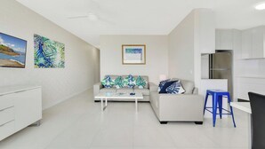 A modern living room with a sofa, coffee table, and artwork on the walls.