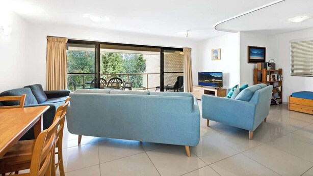 Una sala moderna con un sofá, una mesa de comedor y un televisor.