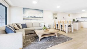 Un salon moderne avec un canapé, une table basse et un coin repas.