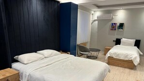 A modern hotel room with a large bed, a smaller bed, a desk, and a chair. - Siya Boutique Hotel (Batman)