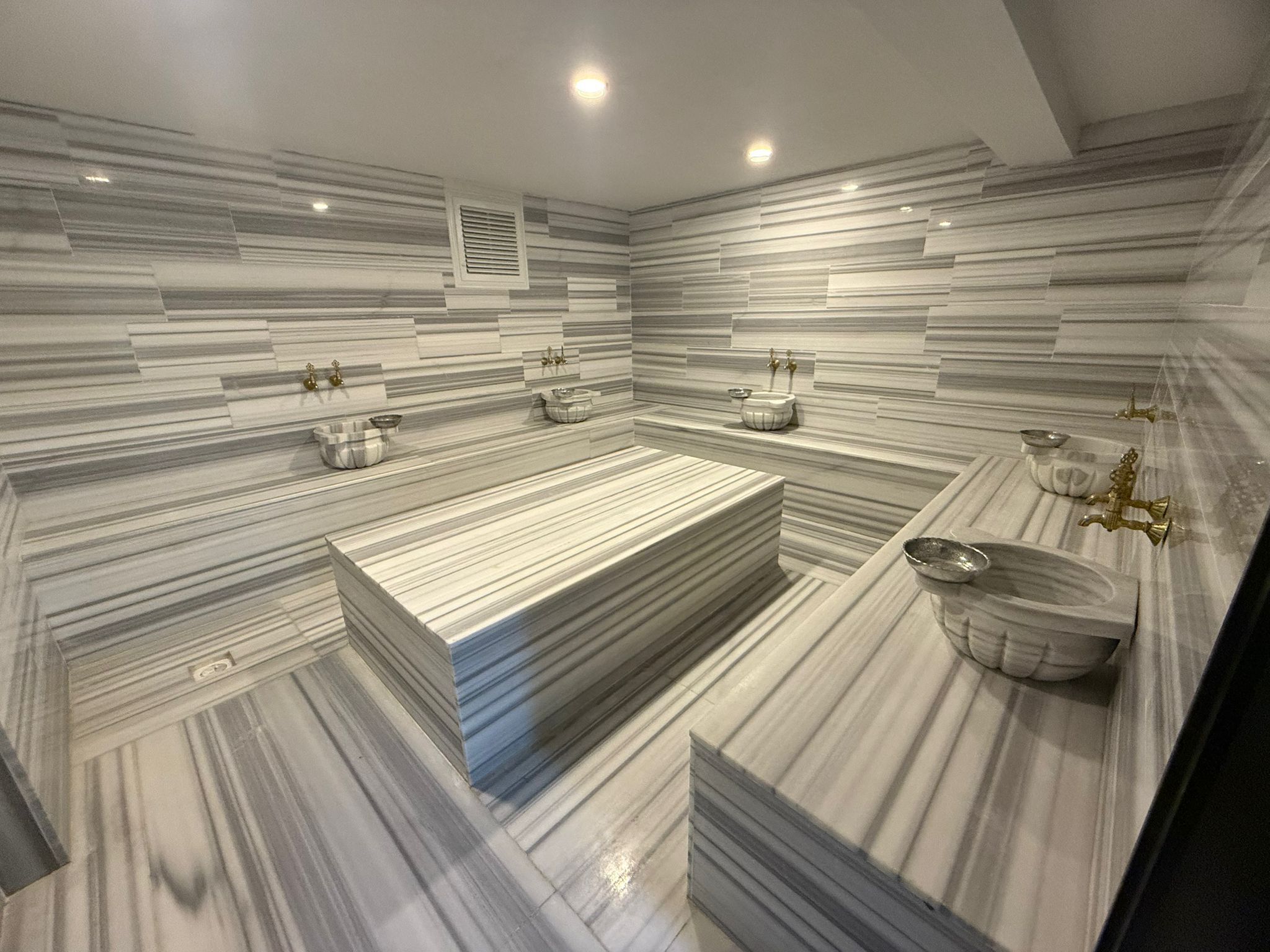Un baño moderno con una bañera rectangular grande, un lavamanos independiente y un mueble de tocador con espejo.