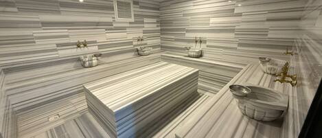 Un baño moderno con una bañera rectangular grande, un lavamanos independiente y un mueble de tocador con espejo.