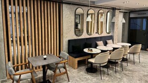 A modern interior with a seating area, tables, and a 'GARDEN' sign. - Siya Boutique Hotel (Batman)