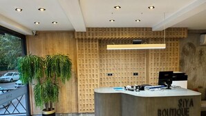 A reception desk with a wooden finish and the text "SIYA BOUTIQUE HOTEL" on it. - Siya Boutique Hotel (Batman)