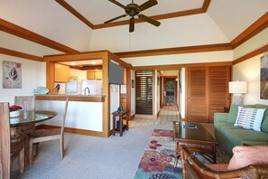 A spacious living area with a dining table, a sofa, and a ceiling fan. - Kiahuna Plantation private Condo, Partial Ocean View, A/C, Steps from Beach #315 (Koloa)