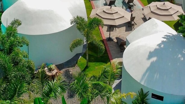 A resort with multiple dome-shaped buildings, a central swimming pool, and outdoor seating areas.