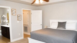 Quarto com cama grande, mesa de cabeceira, cômoda e armário.