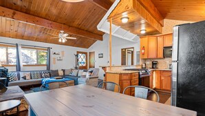 A spacious kitchen with wooden cabinets, a large refrigerator, and a dining area with a wooden table and chairs.