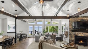 A spacious living area with a fireplace, comfortable seating, and a dining area with a view of the outdoors.