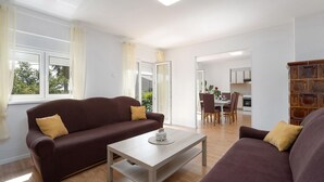Ein Wohnzimmer mit zwei Sofas, einem Couchtisch und einem Essbereich mit Stühlen und einem Tisch.