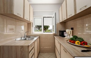 Een koelkast, een oven, een kookplaat, een koffiezetapparaat/waterkoker