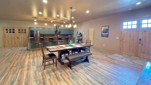 A spacious kitchen with wooden cabinets, a dining table with chairs, and a bench. - Brand New House Right on Allen St one Block from the Birdcage
 (Tombstone)