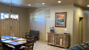 A dining area with a wooden table and chairs, a bench, a cabinet, and a painting on the wall. - Brand New House Right on Allen St one Block from the Birdcage
 (Tombstone)