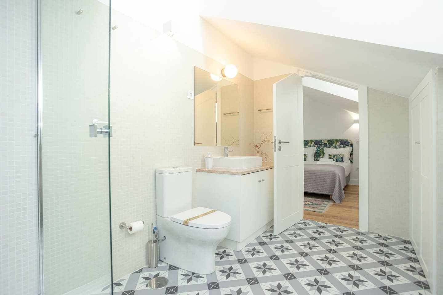 A compact bathroom with a toilet, sink, and shower.