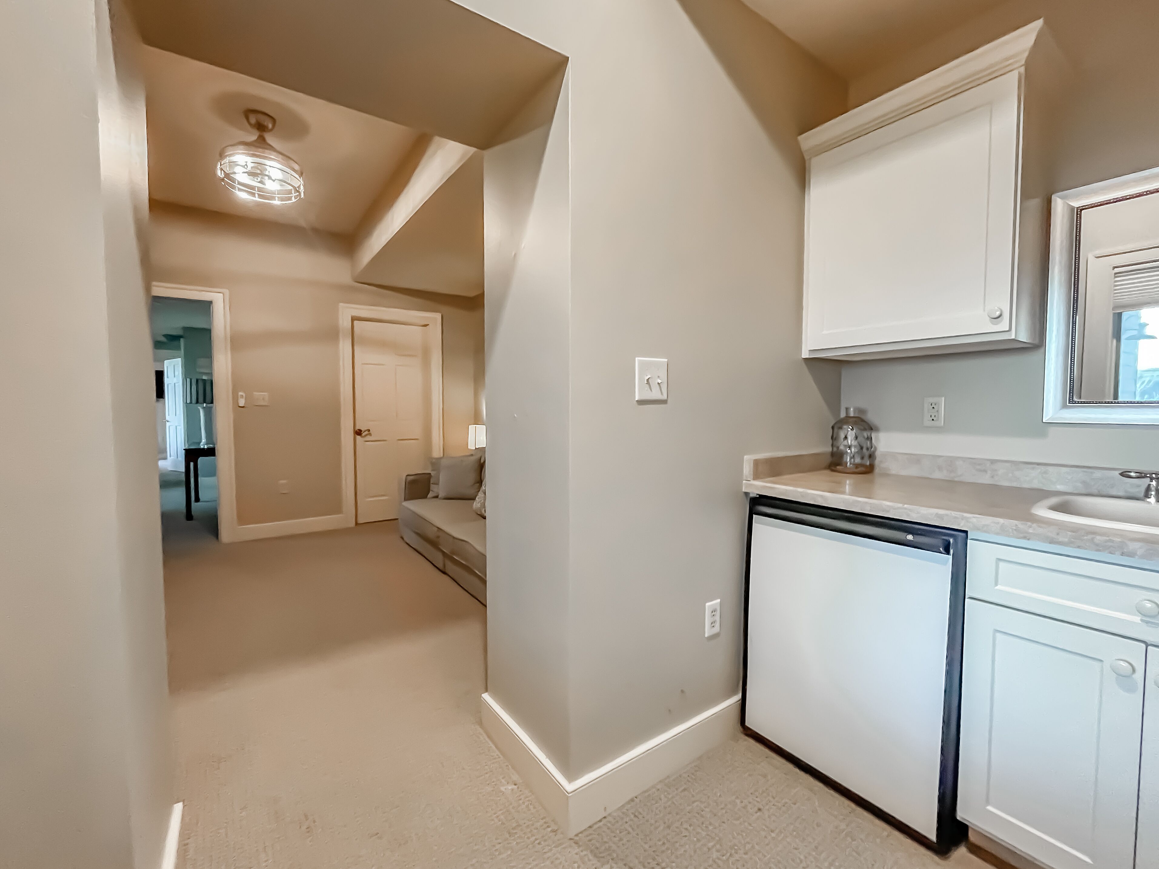 A kitchen with white cabinets, a dishwasher, and a countertop with a sink.