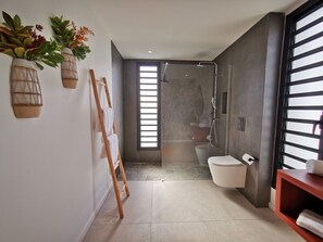 A modern bathroom with a shower, toilet, and a wooden ladder leaning against the wall. - On the beach, modern villa, swimming pool, panoramic sea view , tropical garden (Saint-François)