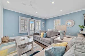 A living room with a grey sofa, a wooden coffee table, and a patterned rug. - Steps from beach! Sleeps 10! Bikes, Xbox, BBQ! (Gulf Shores)