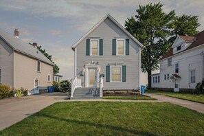 A two-story house with a front porch and a small front yard. - Lakefront Retreat - Serene escape on Lake Erie! Amazing Views! Lorain OH (Lorain)