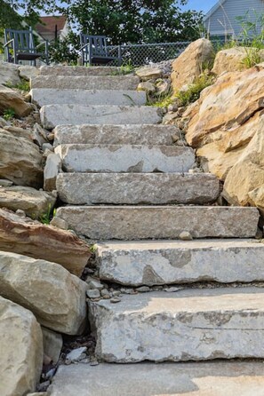 A set of stone steps leading up a hill, surrounded by rocks and vegetation. - Lakefront Retreat - Serene escape on Lake Erie! Amazing Views! Lorain OH (Lorain)