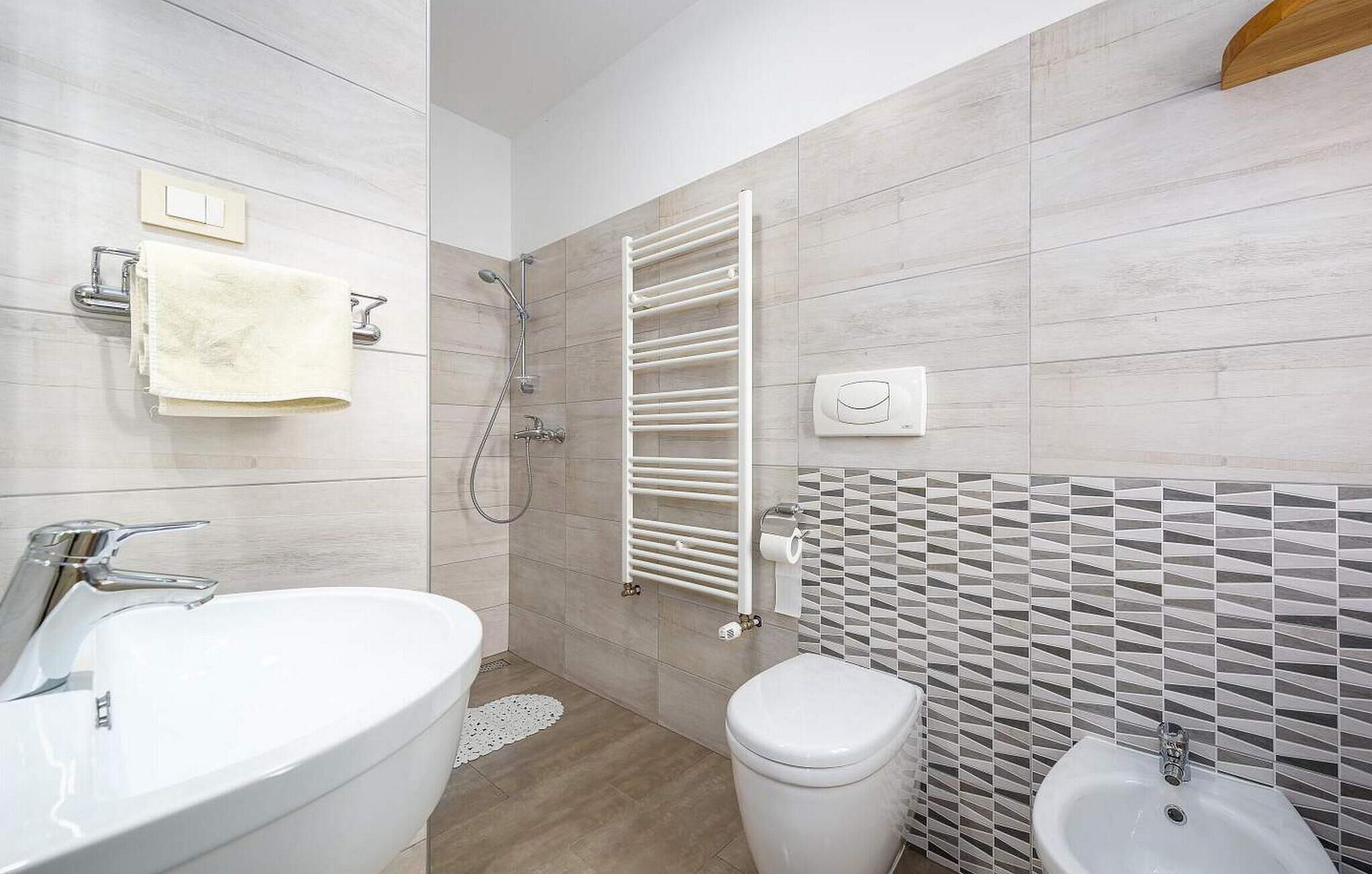Une salle de bain moderne avec un grand lavabo, des toilettes et un bidet.