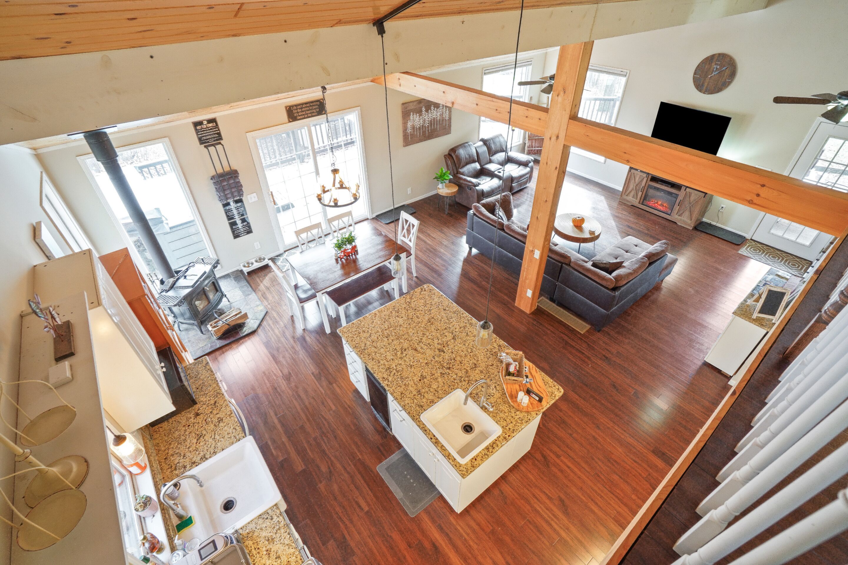 A spacious living area with a fireplace, a dining area with a chandelier, and a kitchen with a granite countertop.