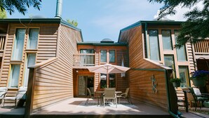 A wooden cabin with a patio area featuring a table and chairs, surrounded by a deck. - Ten Mile Townhouse in Downtown Frisco | Riverside! (Frisco)