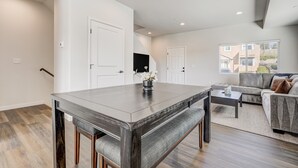 A modern living room with a dining table, sofa, and a view of the outside. - Rising Star (Colorado Springs)