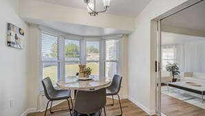 A modern dining area with a round table, four chairs, and a chandelier. - Spacious home With Heated Pool 3 miles from IMG! (Bradenton)